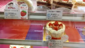 不二家飯能川寺店内のショーケースを撮影した「デラックスショートケーキと「チョコ生ケーキ苺添え」と「ストロベリーロールショートケーキ」を撮影した写真